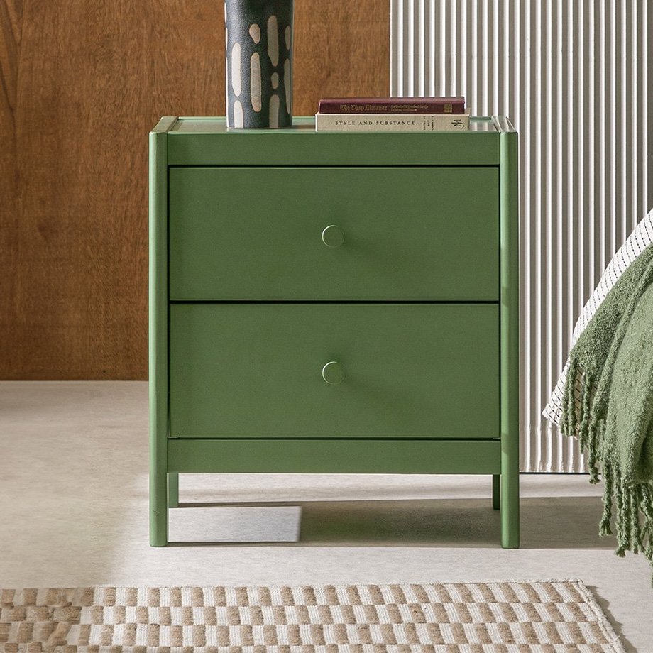 Habitat Bronte 2 Drawer Bedside Table in green colour with a vase on it and placed next to a green bed.